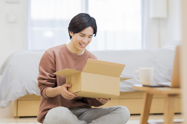 段ボールの中身を確認する男性