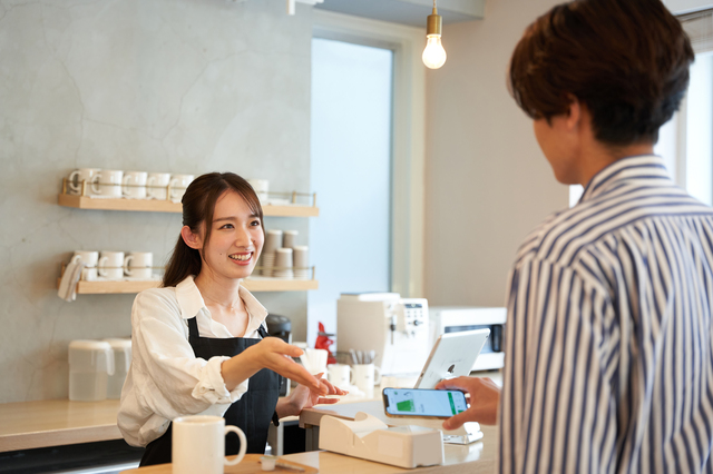 スマホ決済をしている男性