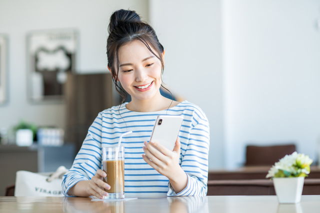 スマホを見つめている笑顔の女性