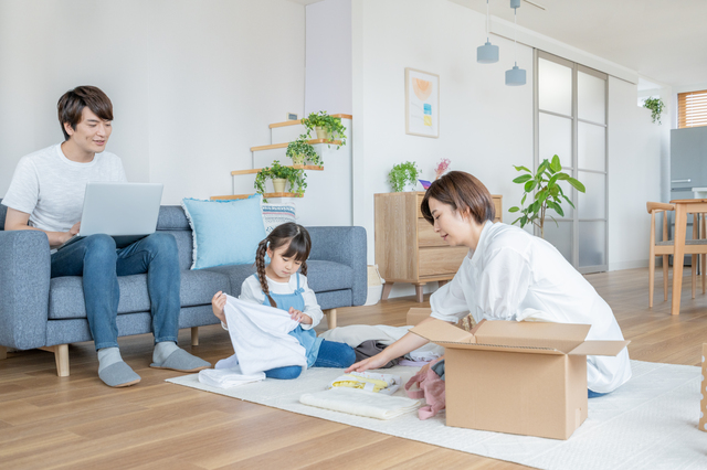 段ボールに詰めるものを整理する家族