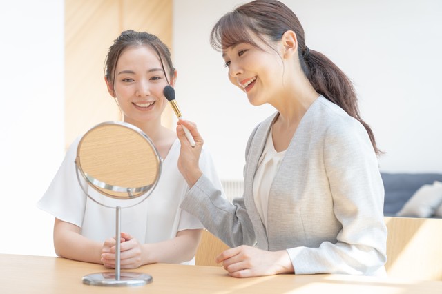 客に化粧をしている店員