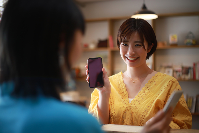 スマートフォンで支払いをする女性