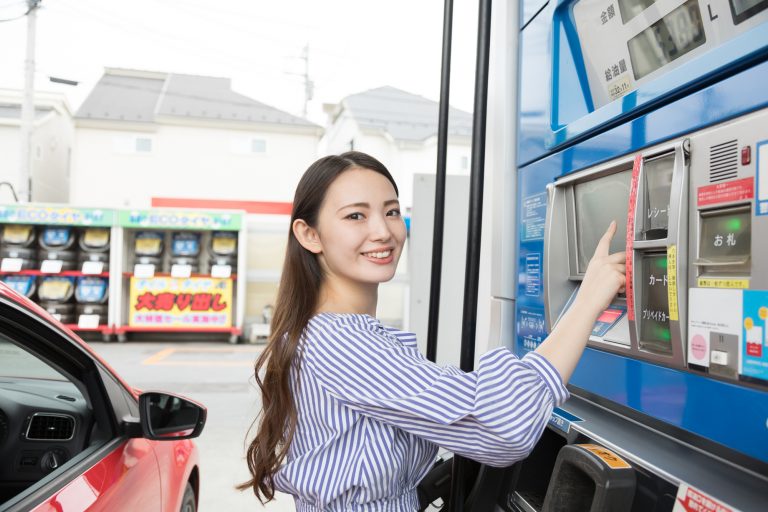 ガソリンスタンドで支払いをする女性