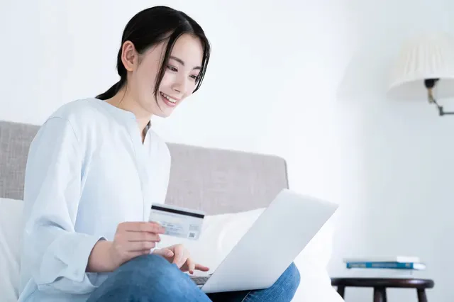 ネットショッピングでカードを利用する準備をしている女性