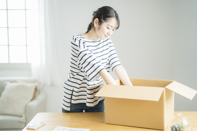 段ボールをあける女性