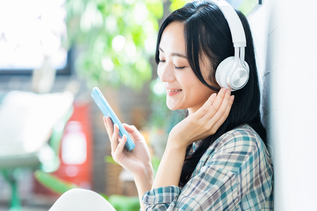 スマホで音楽を聴いている女性