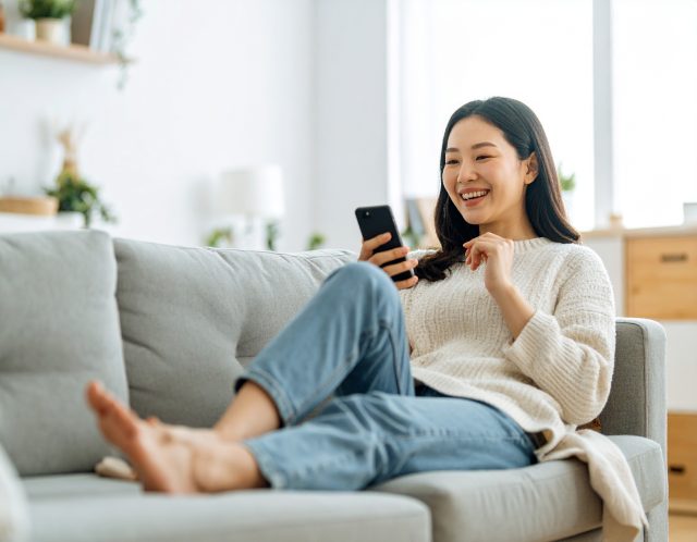 ソファでスマホを操作している女性