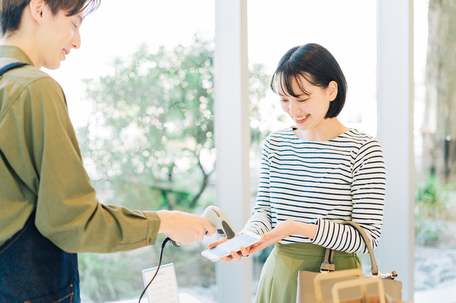 スマホ決済をしている女性