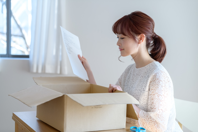 段ボールを開ける女性